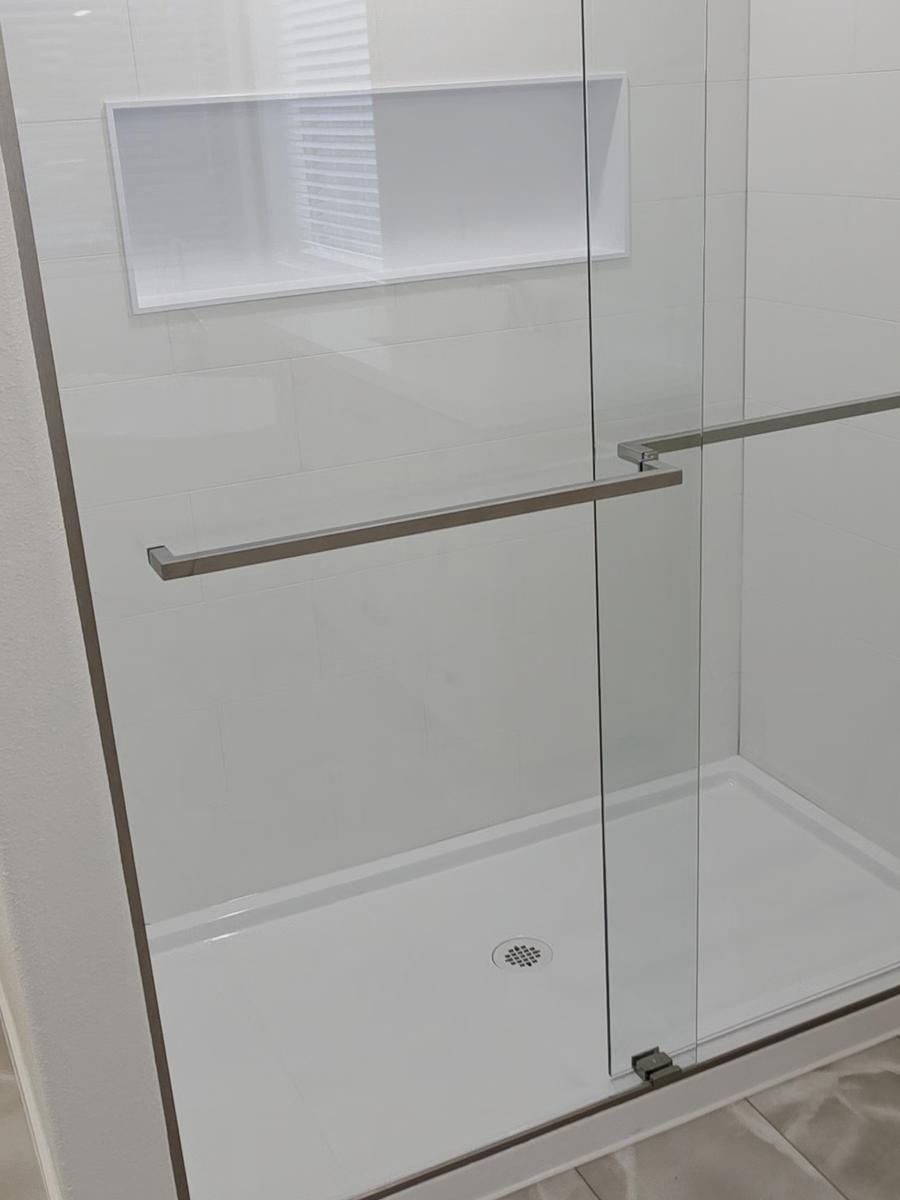 Walk-in shower with glass doors and a niche in the same Kennewick bathroom