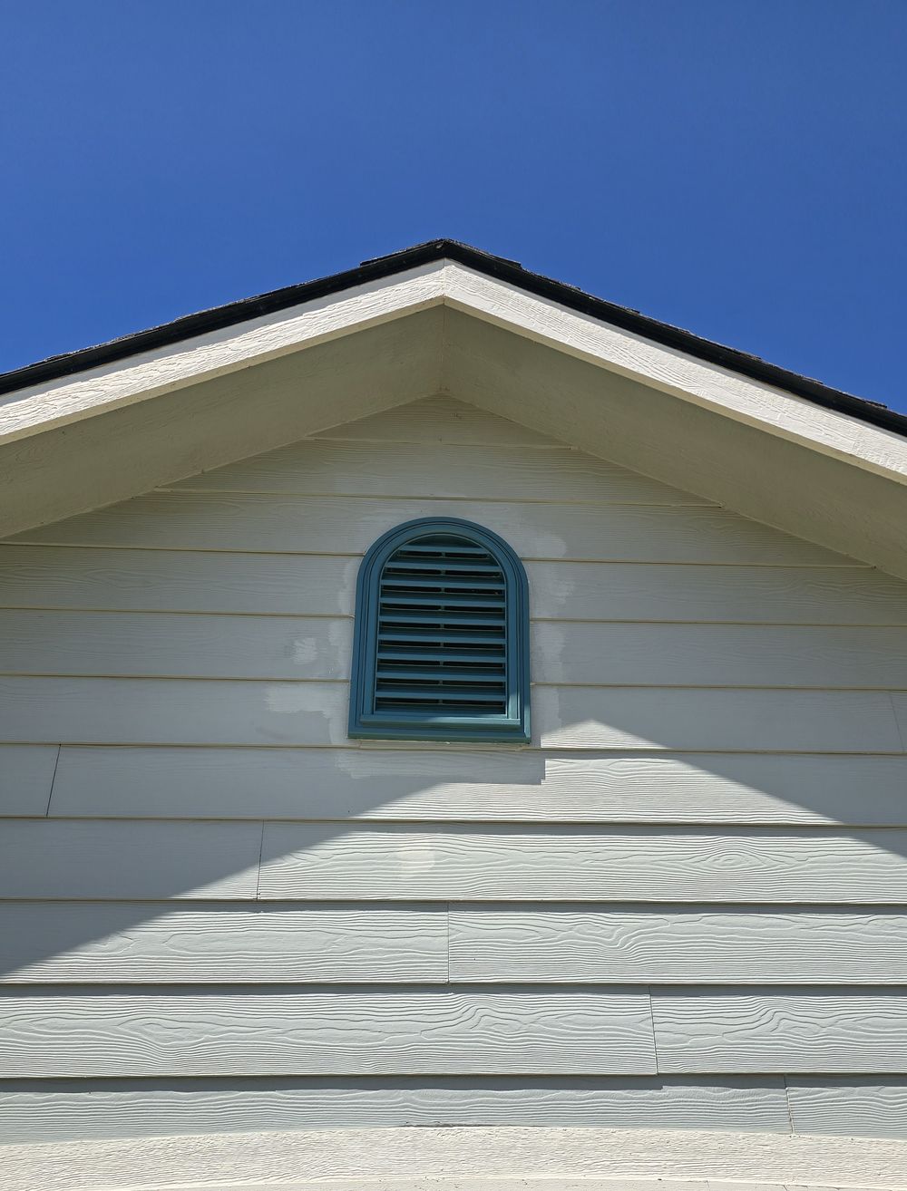Gable attic vent set in lap siding under the roofline