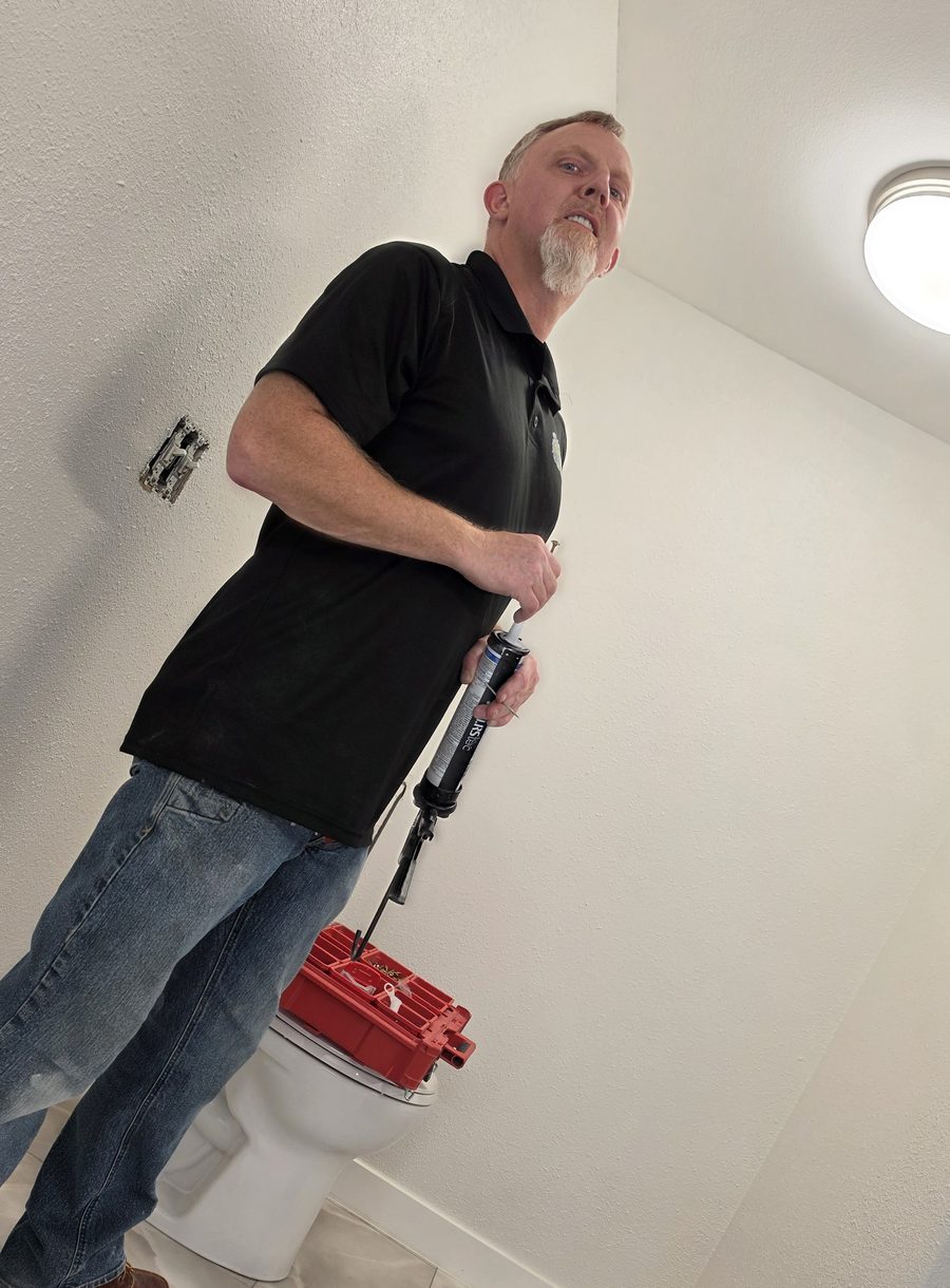 James Hoidal, owner of Speedy's Handyman, with a caulk gun on a bathroom job