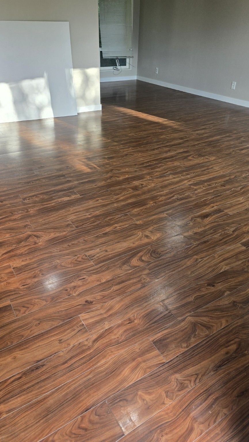 Glossy wood-look floor through a vacant living room on a market-ready refresh