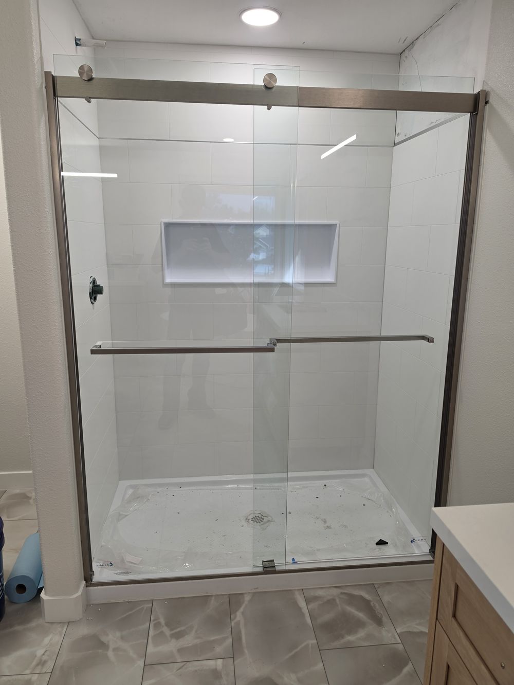 Finished walk-in shower with sliding glass doors and a recessed niche in a Kennewick bathroom remodel