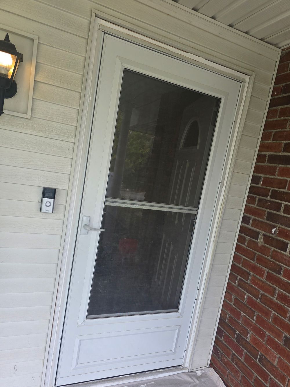 White full-view storm door installed at a front entry