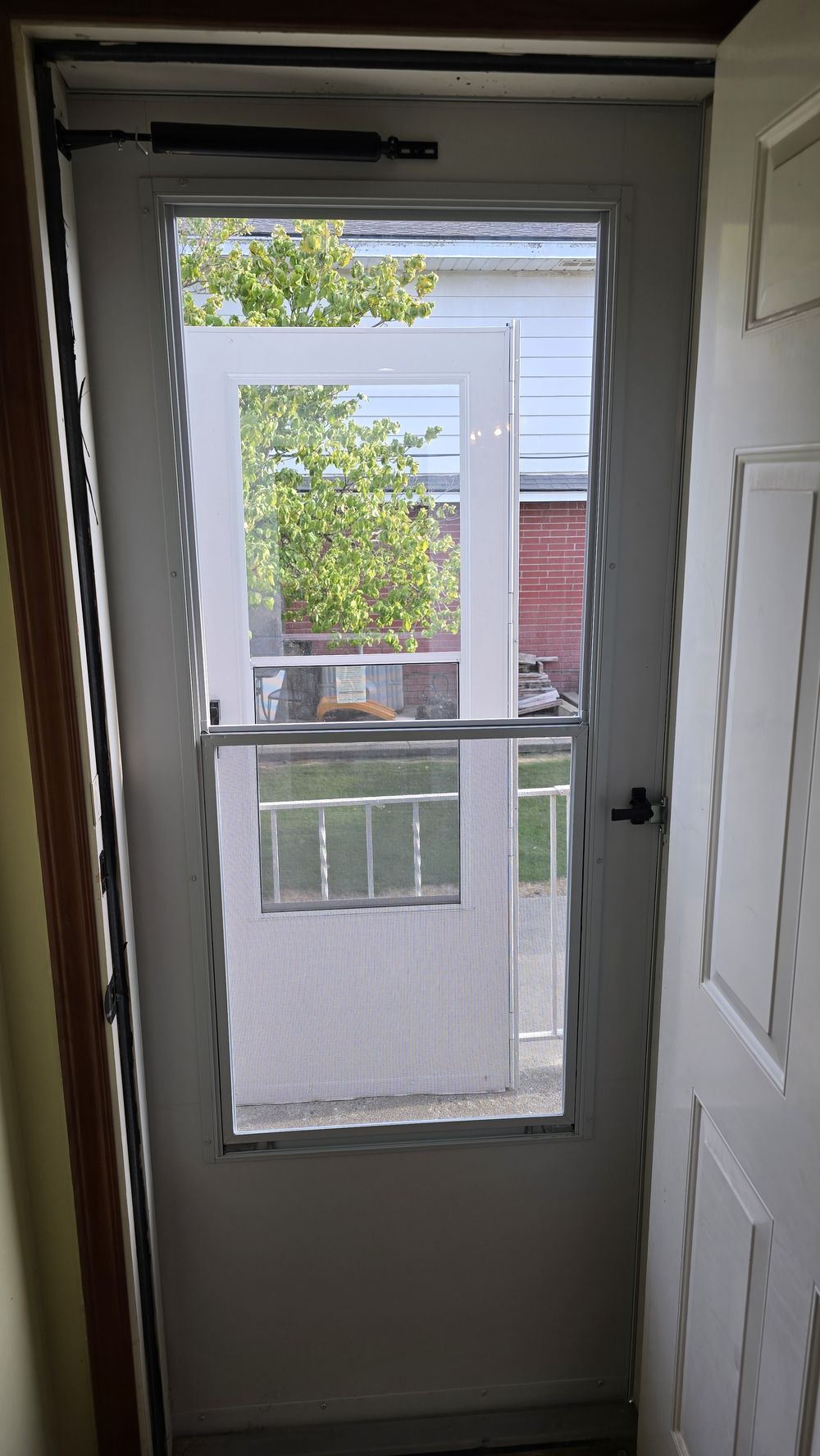 Storm door seen from inside the entry, latched and sealed
