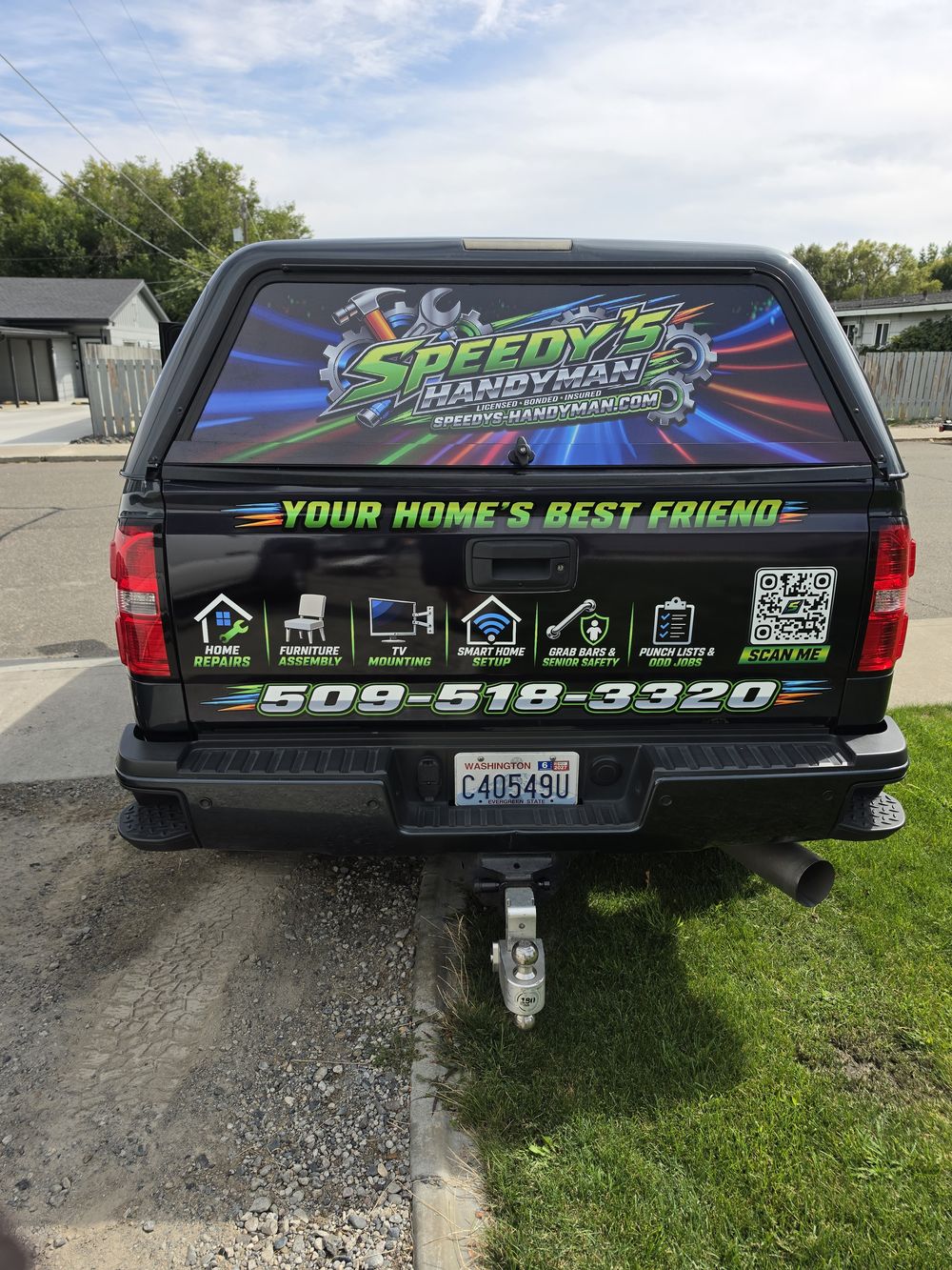 Back of the Speedy's Handyman truck with the wrapped topper and phone number